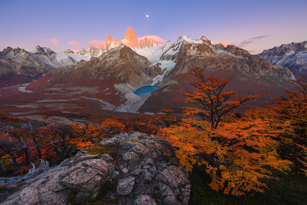 International Landscape Photographer of the Year 2023 third place, a vast landscape of autumn an colour forest and rocky and snow topped mountain ranges