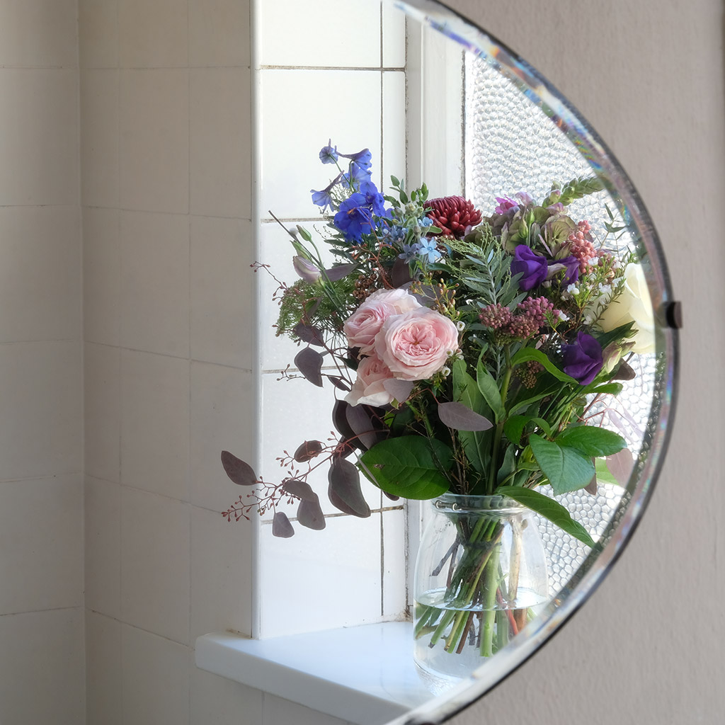 bouquet of flowers reflecting in room mirror