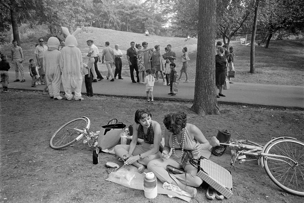 Joel Mayerowitz, black and white image of two ladies having a picnic in a park, two people in rabbit costume, and passers by