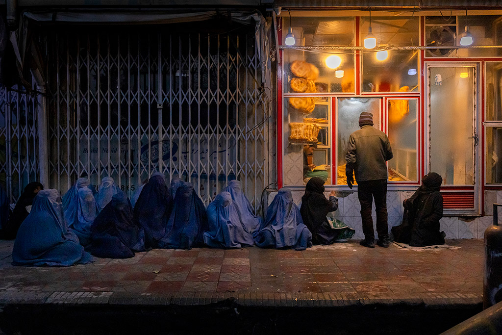 Women and children beg for bread outside a bakery in central Kabul, Afghanistan, on 14 January 2022.