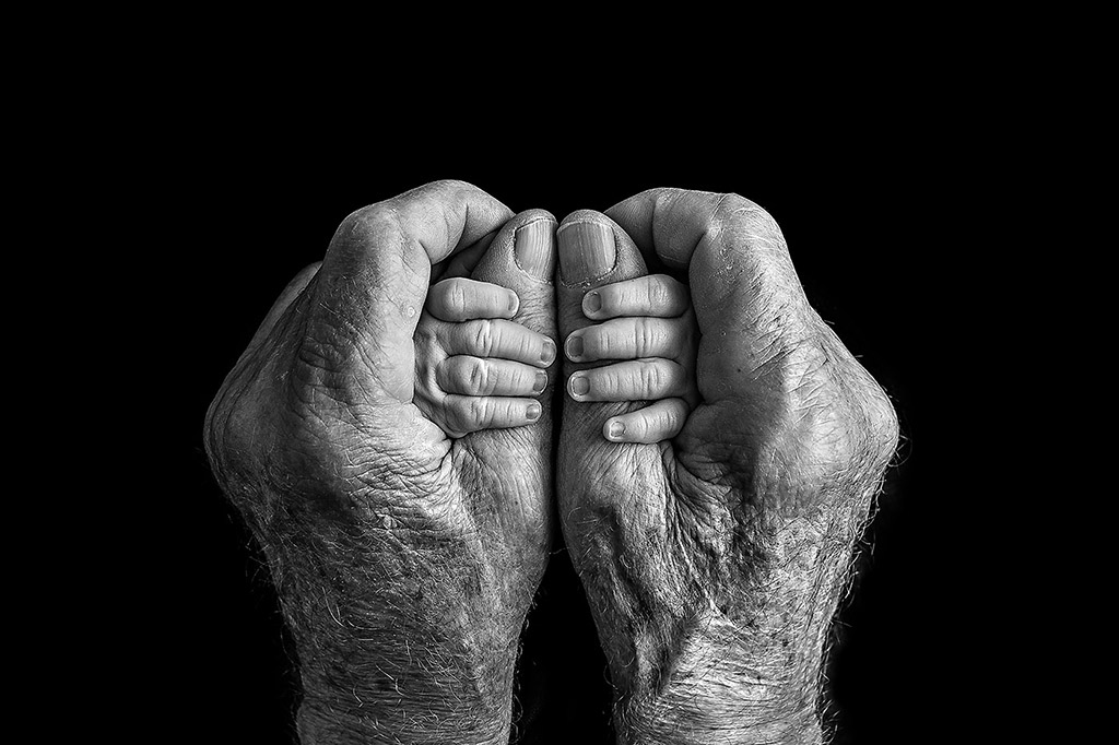 baby hands being held by older person hands winner of black and white minimalist photography awards