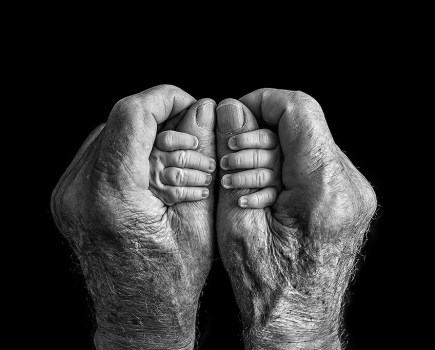 baby hands being held by older person hands winner of black and white minimalist photography awards