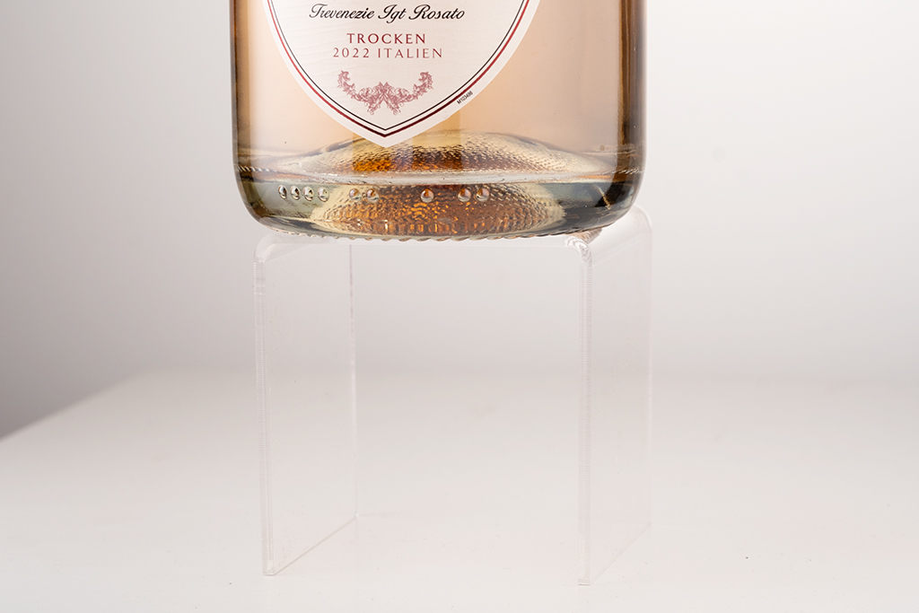 bottom of a rose wine bottle standing on an acrylic cube