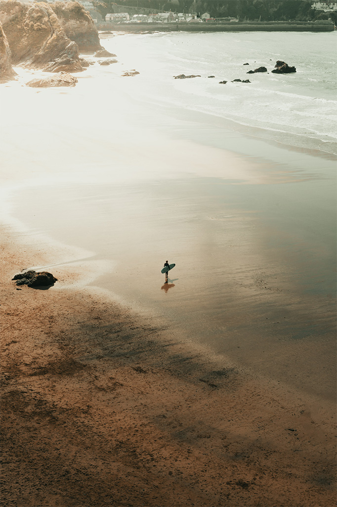 lonely surfer on a beach in cornwall
