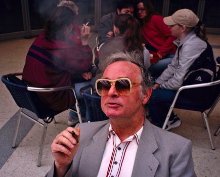 man in sunglasses smoking in front of frame