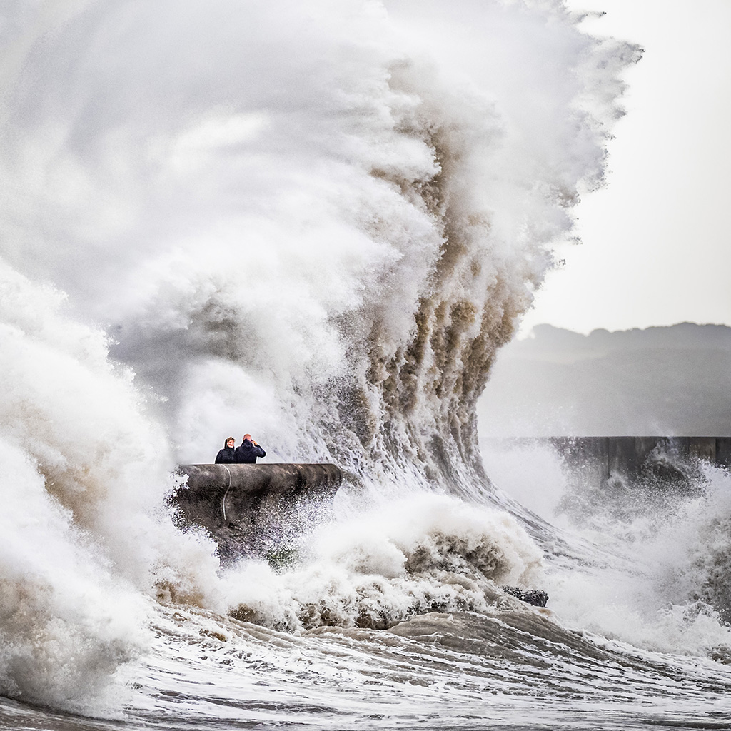 large wave towering over people at a viewpoint