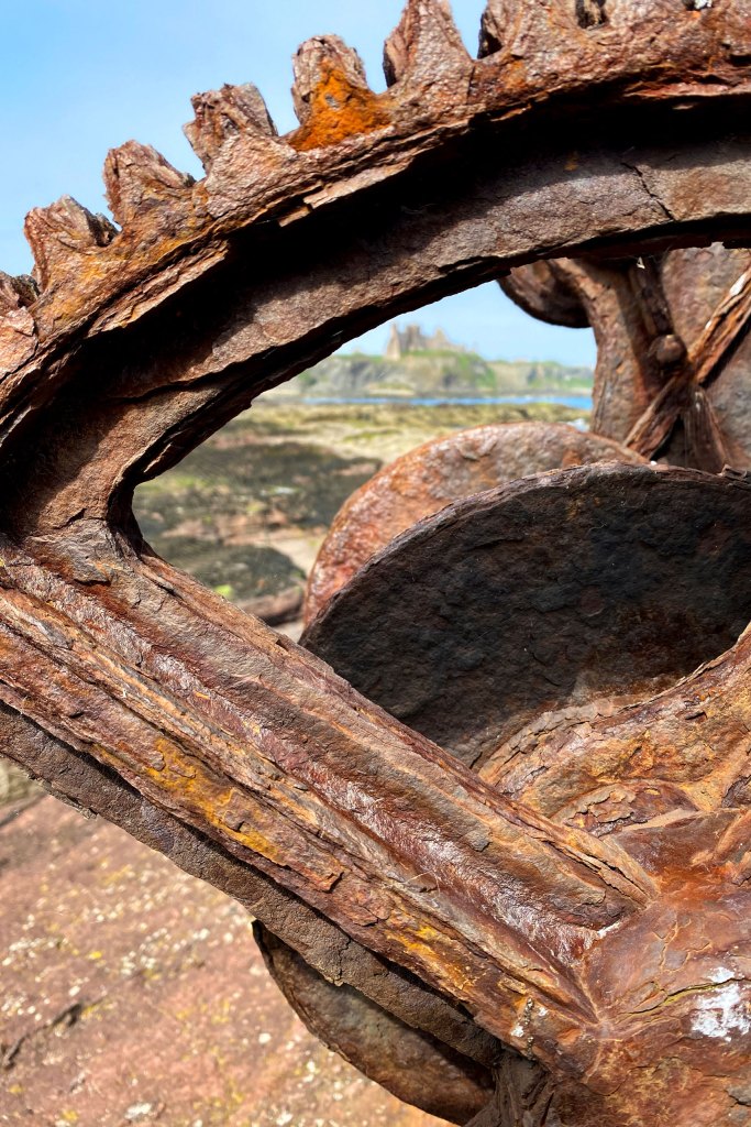 Landscape seen through a rusty cog