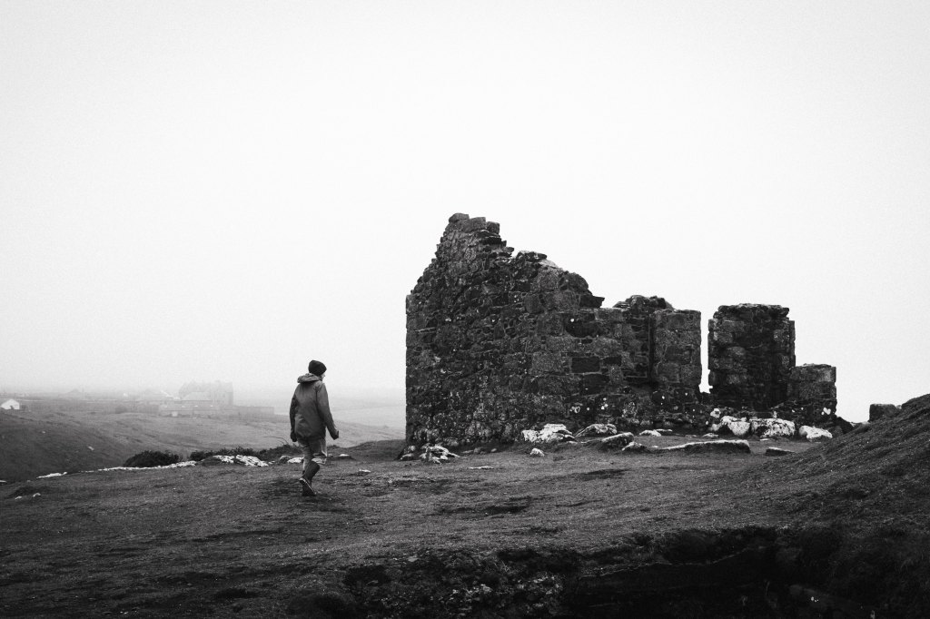 Fujifilm X100VI sample image in black and white, a person walks past ruins