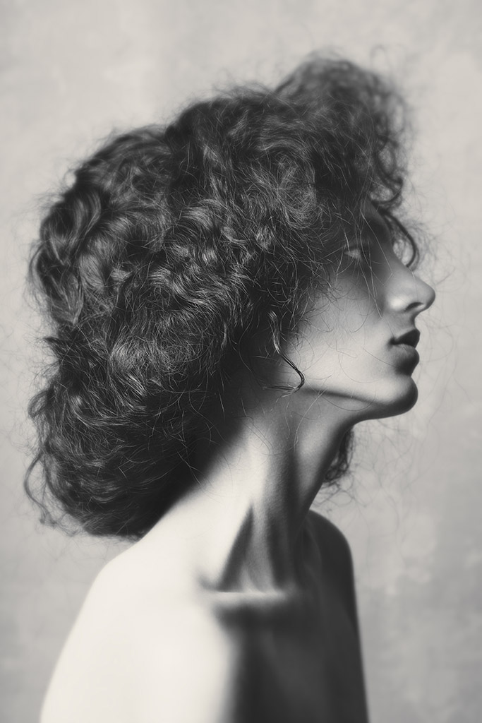 soft and low contrast portrait of a woman showing profile and highlight on collarbone