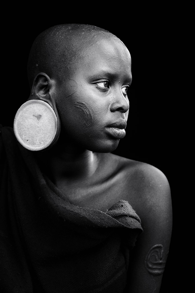 portrait of a girl from the The Suri tribe of the Omo Valley, Ethiopia. Who are renowned for their face painting, but this girl chose to remain unadorned which let her natural beauty shine