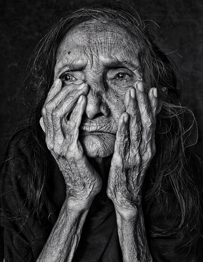 portrait of an older lady with hands around her face