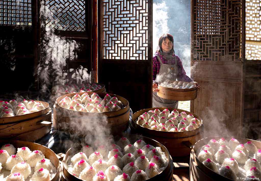 Chinese photographer Zhonghua Yang has been crowned Overall Winner of Pink Lady® Food Photographer of the Year 2024 and awarded the prize of £5,000 (GBP) for his image Red Bean Paste Balls. The photo captures a woman entering a room to add her latest creation to a mountain of steaming dim sum, all prepared for a feast to celebrate Lunar New Year.