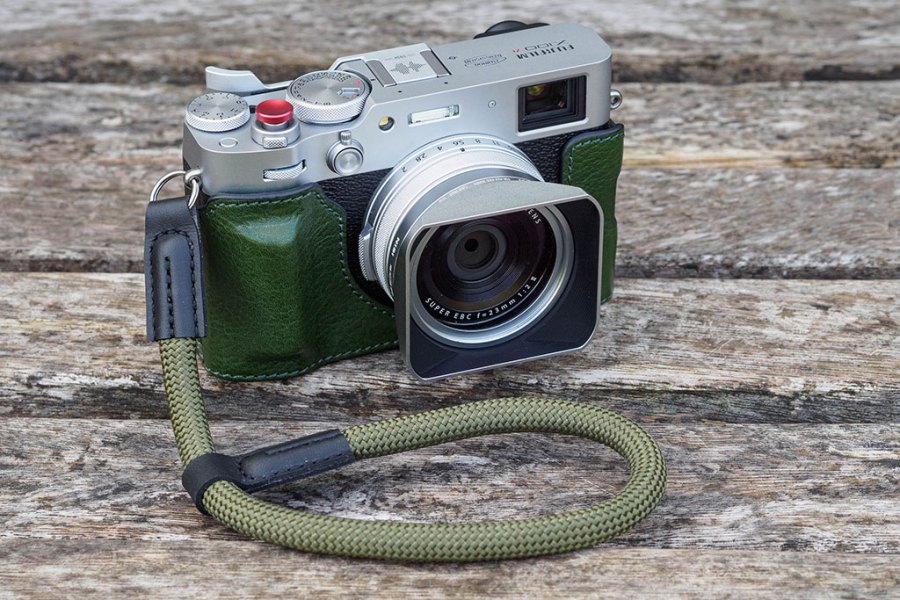 Fujifilm X100VI with half-case, rope strap, hood and thumb grip.