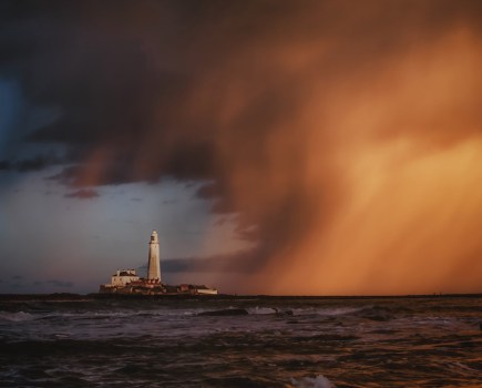 stormy sunset scene over a lighthouse