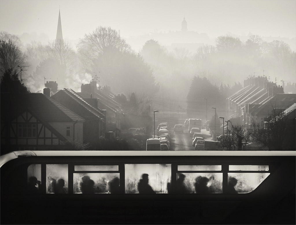 composite of bus in the foreground and misty urban scene in the background