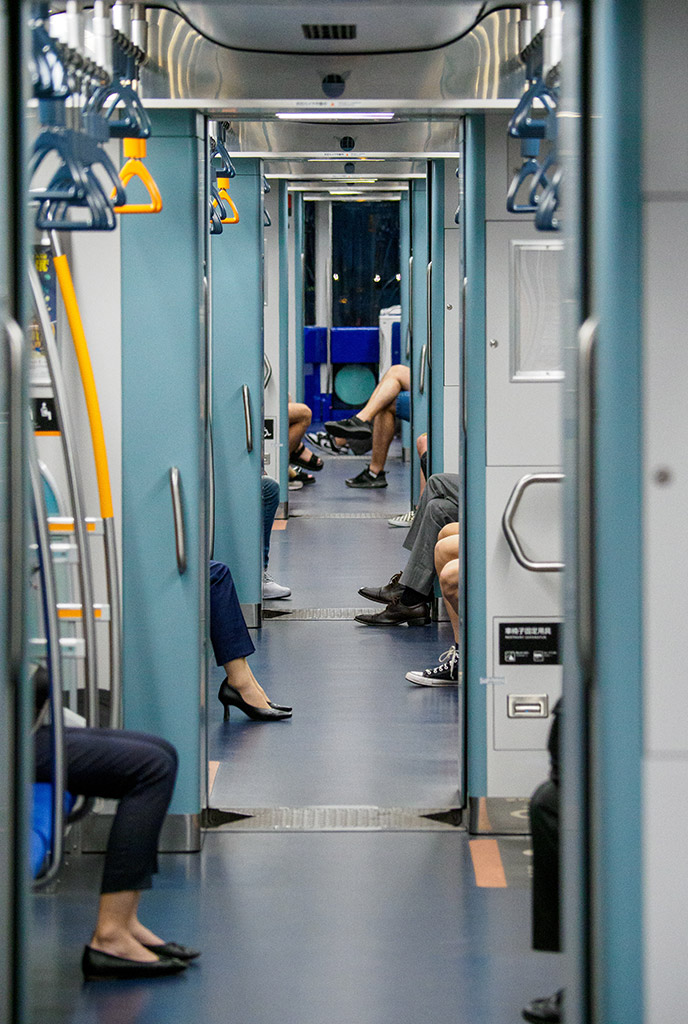 looking down a train carriage only seeing peoples feet