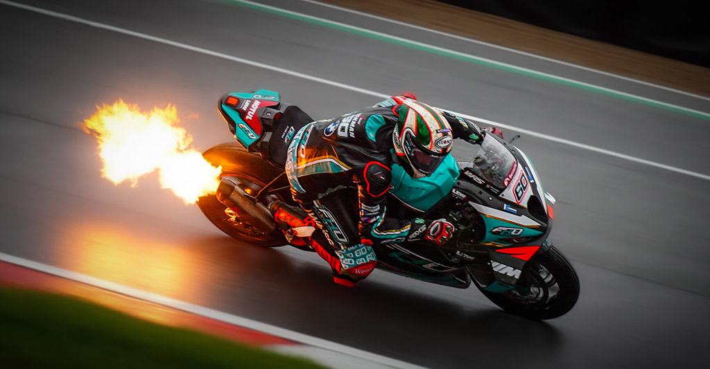 motorbike with flames coming out the back during race