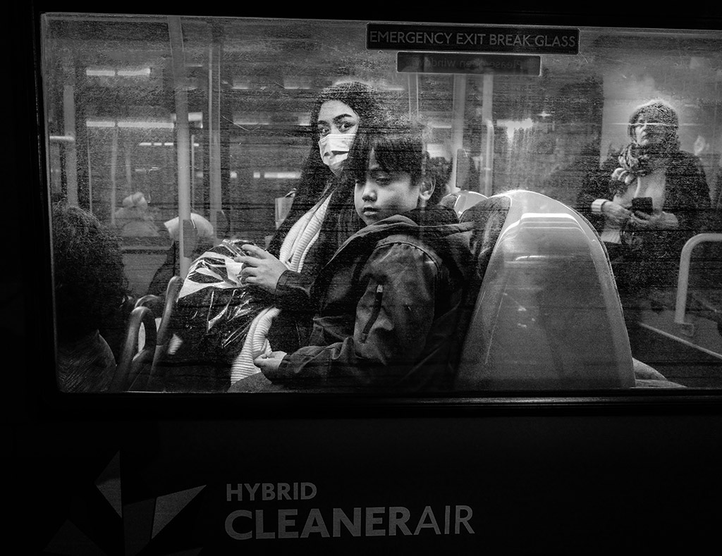 night scene looking through bus window to woman and child passenger