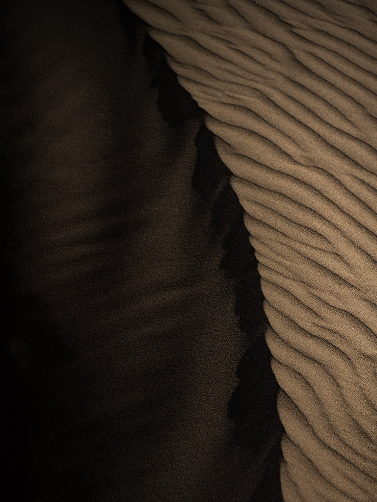 contrasted image of a sand dune, really dark shadow on one side