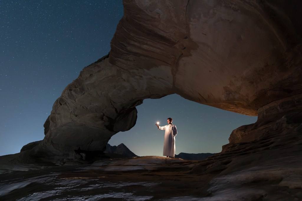 A man with a torch at night in the Jordan Wadi Rum