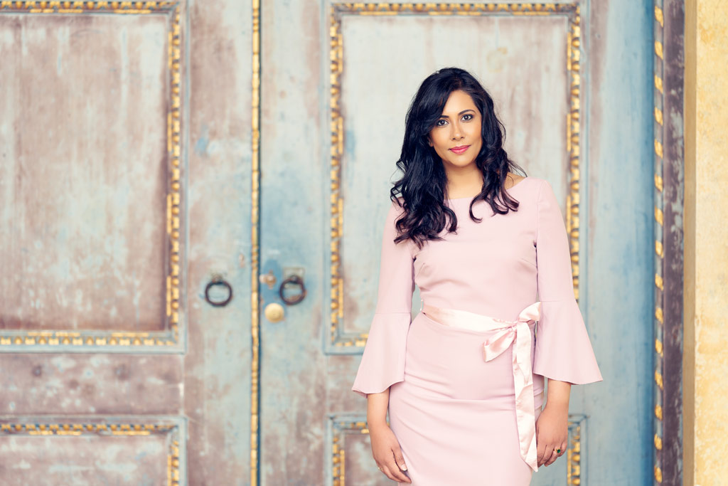 portrait of a woman in a pink dress against a weathered door