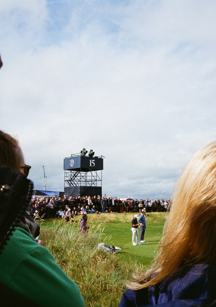 looking through people's heads towards hole 15 of the open