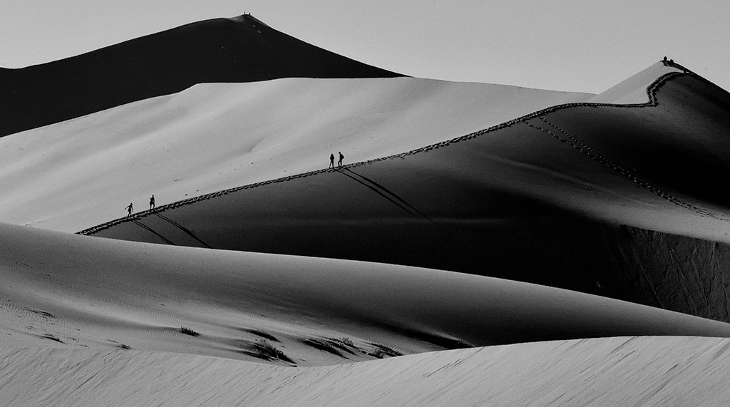 Namibian sand dunes with people walking in the landscape in the distance