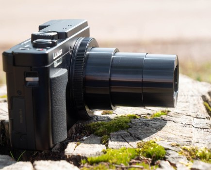 The Panasonic TZ95 sitting on a log, with the zoom extended. Image: Amy Davies