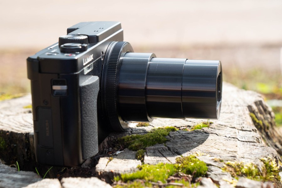 The Panasonic TZ95 sitting on a log, with the zoom extended. Image: Amy Davies