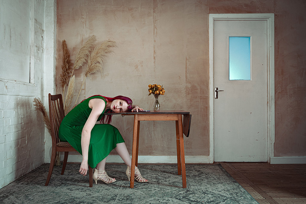 woman in green dress leaning over table