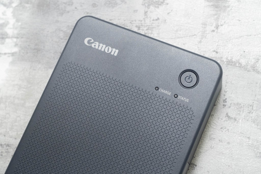 A close-up of the power button of the Canon Selphy QX20