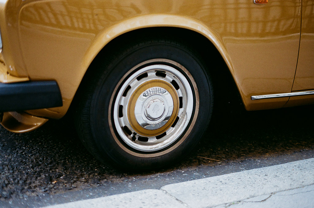 close up photo of an old yellow Rolls-Royce wheel