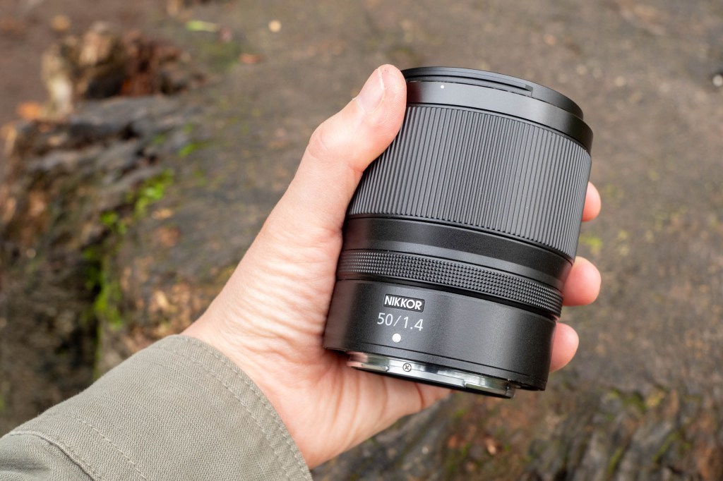 The Nikon 50mm f/1.4 lens in hand