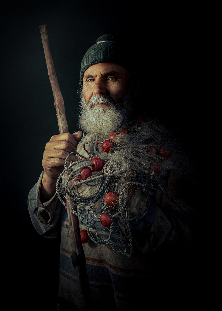 atmospheric portrait of a fisherman with netting around his torso winner young apoy people round