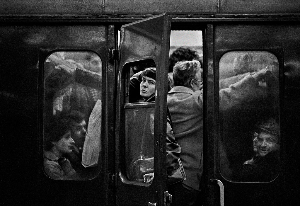 black and white photo person looking out of train window