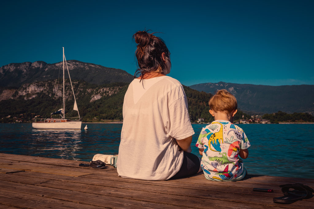 travel photography, a woman and a small child sitting on a pier 