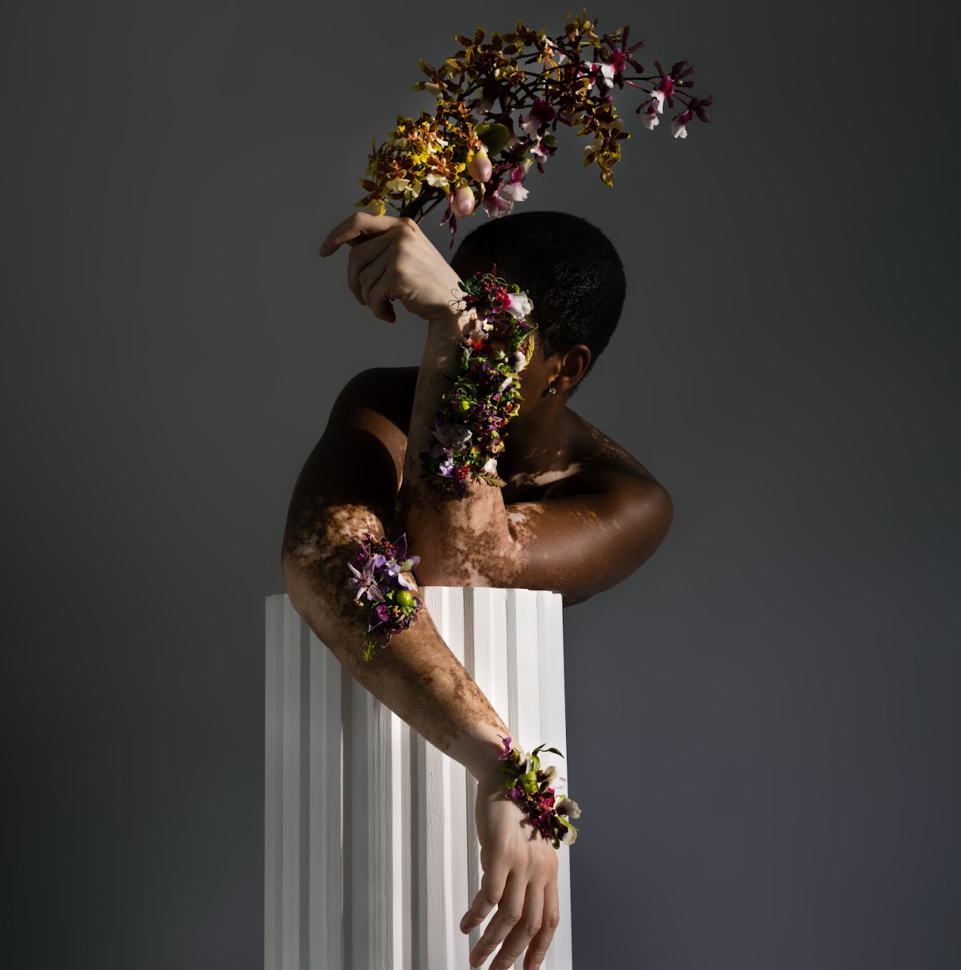 portrait of person with golden foliage prop in front of face