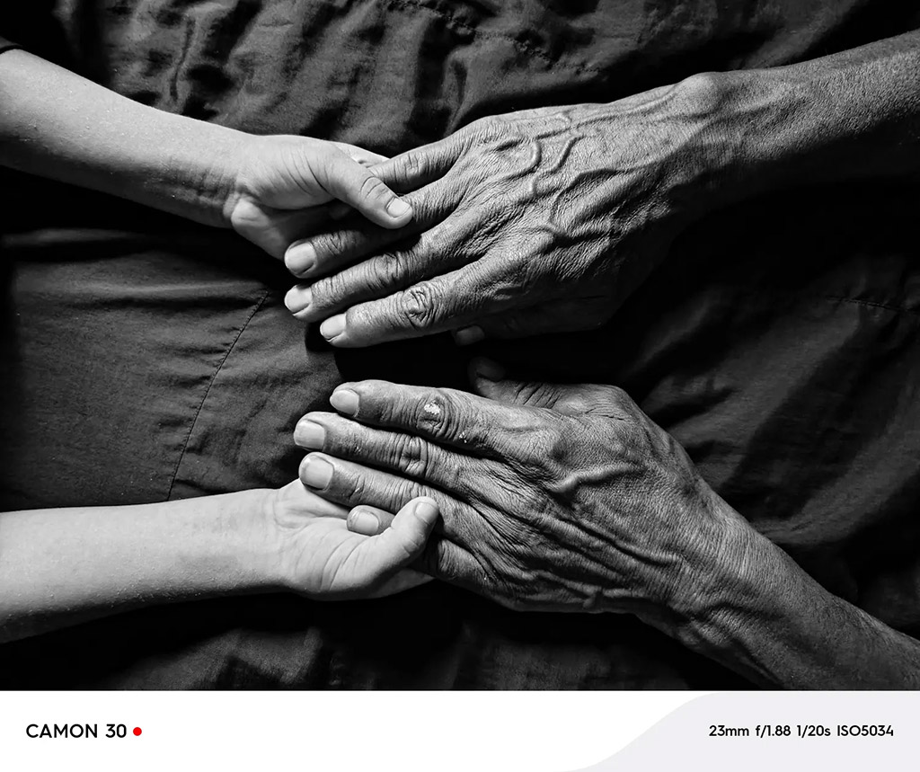 photo from above taken of older hands holding young hands