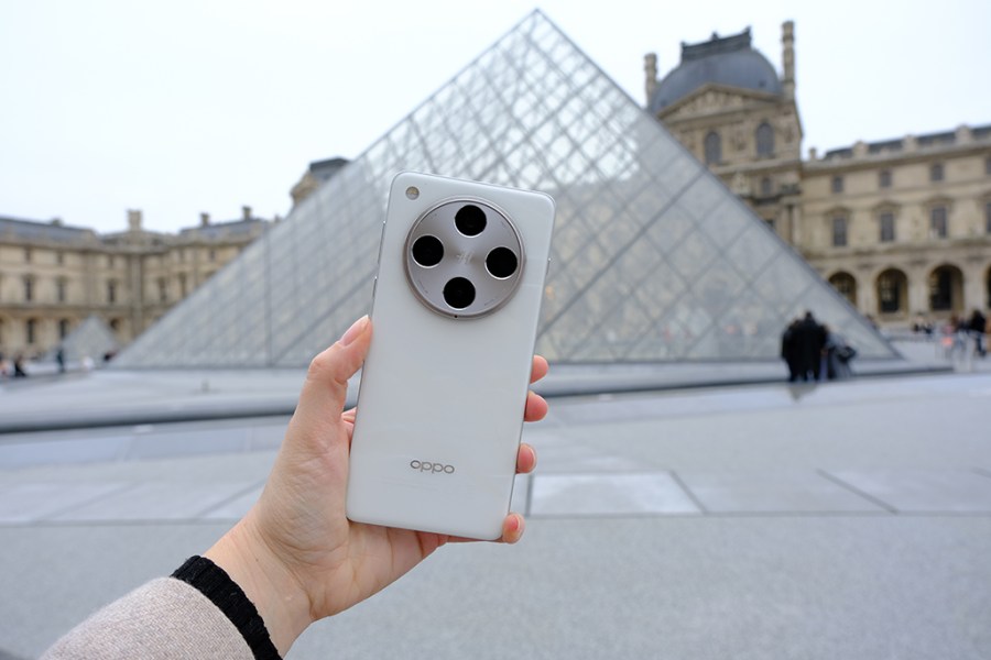 holding the oppo find x8 pro in front of the louvre