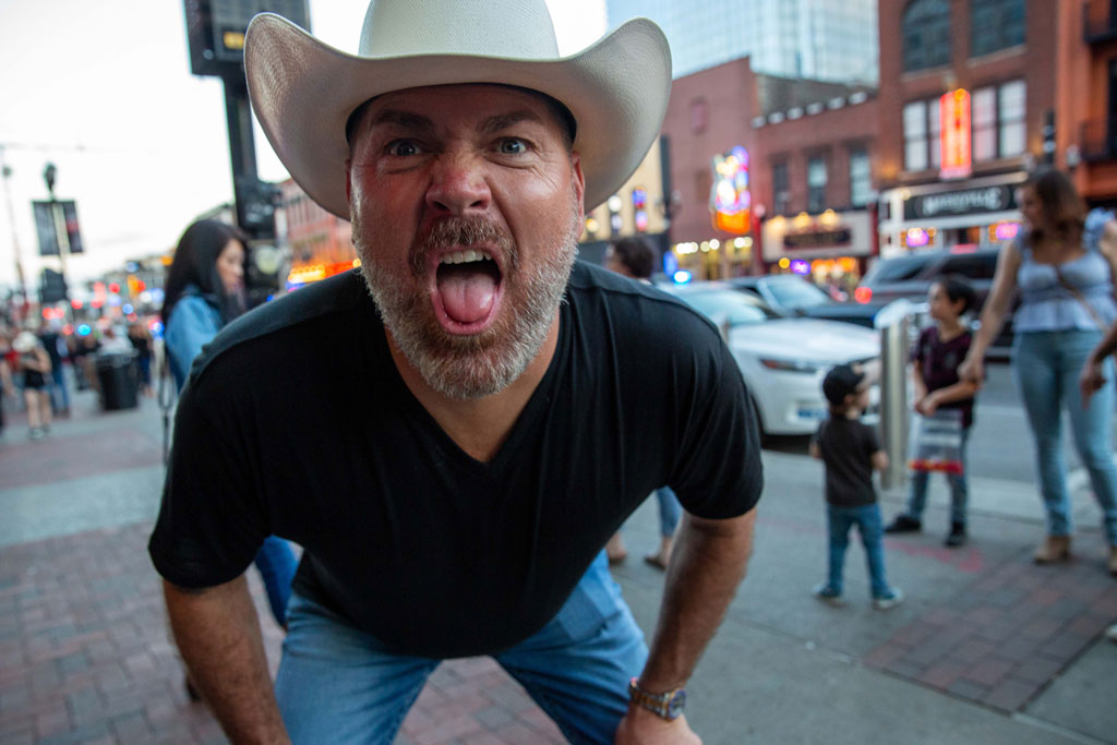 Nashville, a man in a cowboy hat up close to the camera grimaces