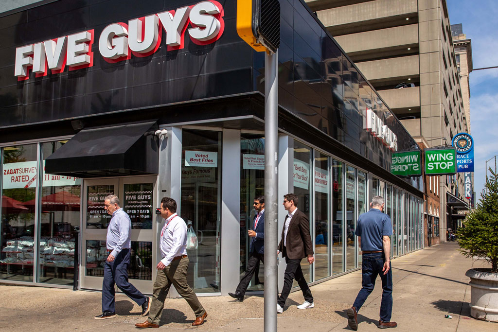 Indianapolis, five man walking past a Five Guys fast food place