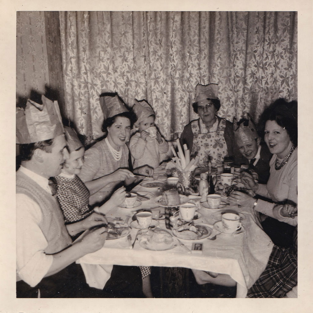 Old digitised photograph from the 1960, family sitting around a table at a Shristmas dinner. Family archive