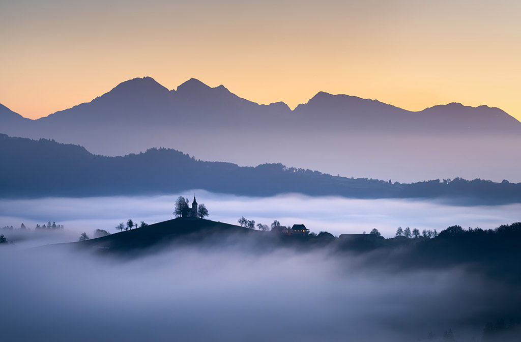 misty landscape scene with mountains in the background