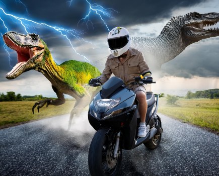 Adobe Generative AI image, generated with the prompt "Man riding moped on road being chased by lightning and dinosaurs." This example is being used as Adobe were advertising this kind of image as a reason why you'd want to use generative AI.