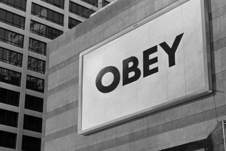 OBEY sign from the film They Live. The wheels of capitalism and consumerism are difficult to avoid. Image: They Live (1988 film).