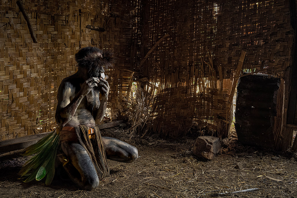 low-lit image of Papua New Guinean Wauga tribespeople in the Central Highlands