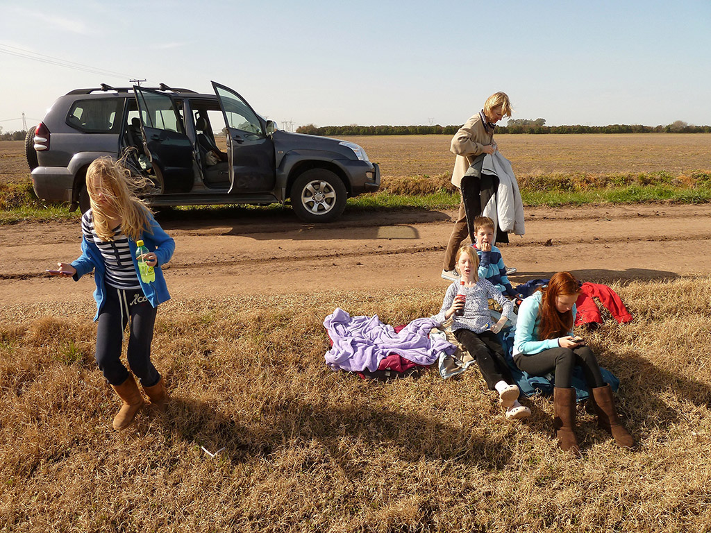 dishevelled family on holiday taking a much-needed break by the side of the road