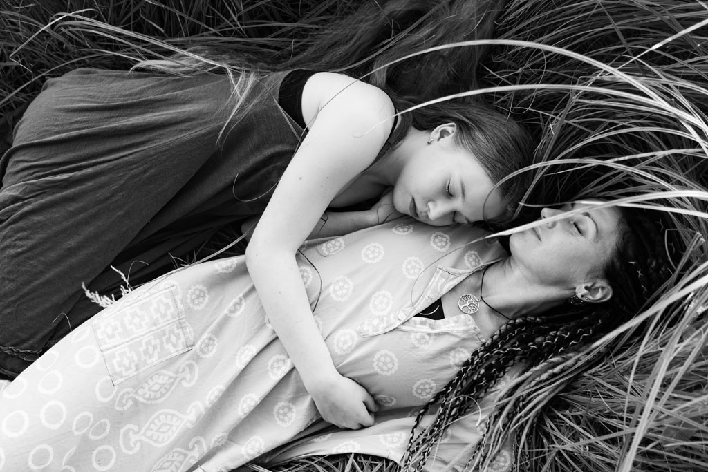 mother and daughter laying in high grass, black and white image