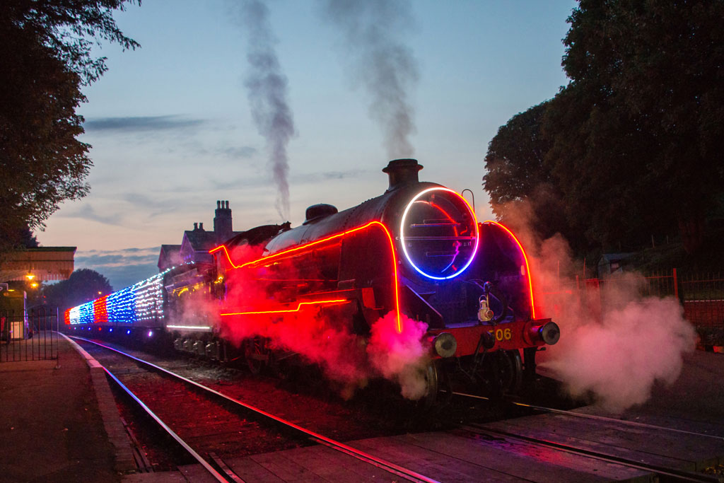 a steam train decorated on the outside with colourful led lights