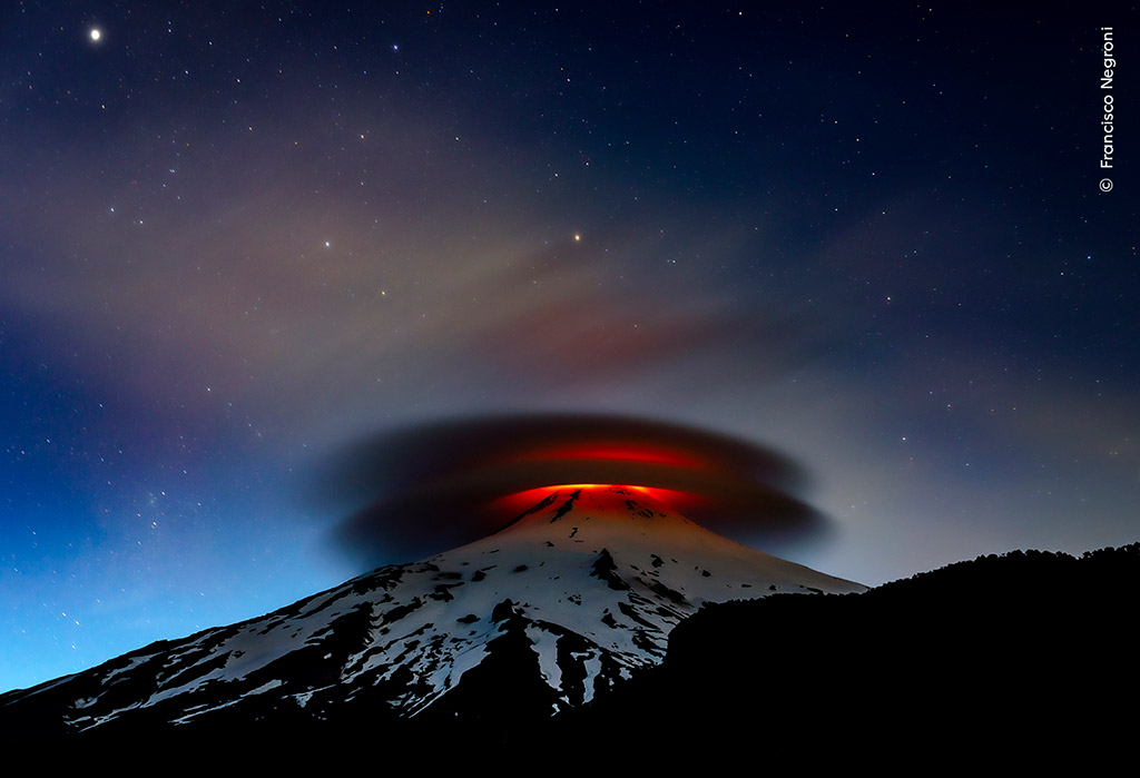  double lenticular cloud illuminated at nightfall by lava emitted from the Villarrica volcano in Chile